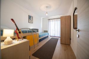 a room with a bed and a guitar in it at Apartman Elvis in Lovran