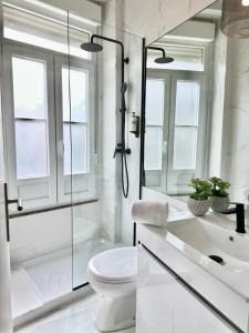 y baño blanco con ducha y aseo. en YOUROPO - Capela, en Oporto