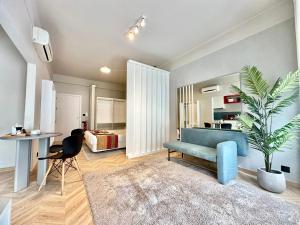 a living room with a blue couch and a plant at YOUROPO - Capela in Porto