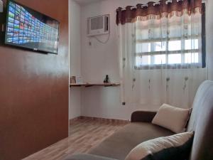 a living room with a couch and a window at Conforto 100 mts da praia in Barra de São Miguel