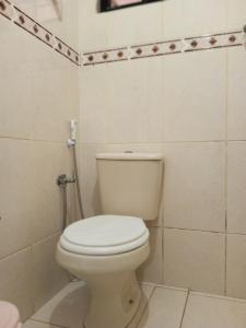 a bathroom with a white toilet in a room at Conforto 100 mts da praia in Barra de São Miguel