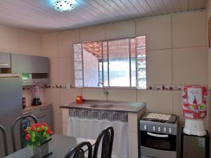 a kitchen with a sink and a stove top oven at Conforto 100 mts da praia in Barra de São Miguel
