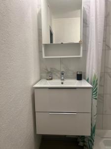 a bathroom with a white sink and a mirror at Cocon Accès facile Parking Gratuit in Belfort