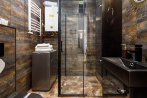 a bathroom with a glass shower and a sink at Pet-Friendly Apartment with Air Conditioning Jagiellońska by Noclegi Renters in Darłówko