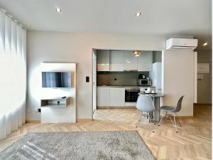 een keuken met witte kasten en een tafel en stoelen bij YOUROPO - Capela in Porto