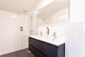 a white bathroom with a sink and a mirror at Weber Hotel in Amsterdam