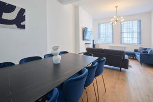 a living room with a black table and blue chairs at Host & Stay - Castle View in Scarborough
