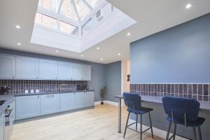 a kitchen with blue cabinets and a skylight at Host & Stay - Castle View in Scarborough +21 photos