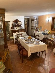un comedor con mesas con manteles blancos en La torre della manca suite, en Sasso di Castalda