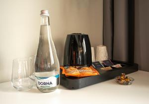 a bottle and a glass on a table with a box at ibis Bucharest Politehnica in Bucharest