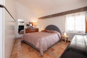 um quarto com uma cama, uma cómoda e uma janela em Altana Rialto Apartment em Veneza