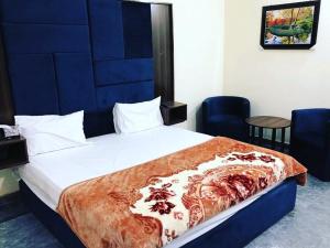 a bedroom with a large bed with a blue headboard at Hotel Air inn in Lahore