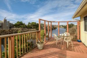 a wooden deck with a table and chairs on it at Shore Delight Waldport Home and Deck, Walk to Beach in Waldport