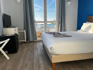 a bedroom with a bed and a large window at Hôtel du Bord de Mer "Le Vanillé" in Cagnes-sur-Mer