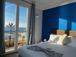 a bedroom with a bed with a view of the ocean at H&ocirc;tel du Bord de Mer "Le Vanill&eacute;" in Cagnes-sur-Mer