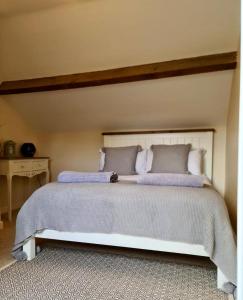 a bedroom with a large white bed with pillows at Newditch Farm - BRS Airport in Bristol