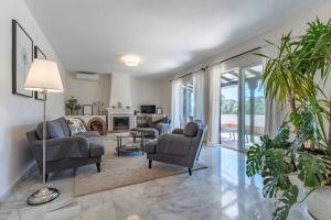 Una sala de estar con sofás y sillas y una chimenea. en Holiday Villa Torrenueva, en La Cala de Mijas