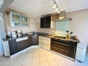 a kitchen with black cabinets and a counter top at Maison familiale du Devallon in Saint-Jean-de-Monts +15 photos