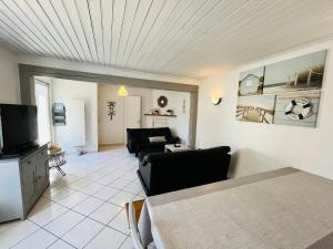 a living room with a couch and a tv at Maison familiale du Devallon in Saint-Jean-de-Monts