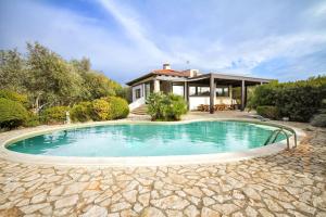 a swimming pool in front of a house at ClickSardegna Villa Paraiba fronte mare per 12 persone in Alghero