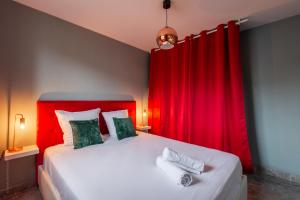 1 dormitorio con 1 cama grande y cortinas rojas en The Movies - Fairytale Factory, en Montévrain