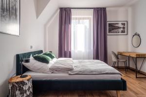 a bedroom with a bed and a window with purple curtains at Ostoja Rakówiec in Dobre +44 photos