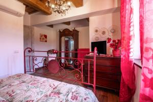 Schlafzimmer mit einem roten Bett und einem Spiegel in der Unterkunft Appartamento Rosso - Monte Crespini in Manciano