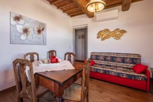 ein Esszimmer mit einem Tisch und einem Sofa in der Unterkunft Appartamento Rosso - Monte Crespini in Manciano