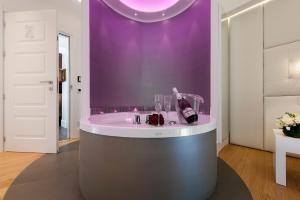 un bagno con lavandino rotondo e parete viola di Argentina Residenza Style Hotel a Roma