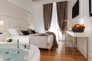 a white bedroom with a bed and a tub in it at Argentina Residenza Style Hotel in Rome