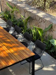 una mesa de madera con 4 sillas y una pared de piedra en Casa Blumenhaus - Casa de Campo con Jacuzzi en Zapopan, en Zapopan