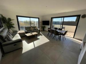 salon z kanapą i stołem w obiekcie Grande Villa cosy avec piscine, sauna & jacuzzi w mieście Juvignac