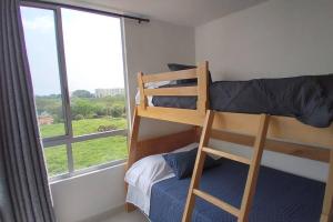 a bunk bed in a room with a window at Hermoso Apartamento Ricaurte Peñazul La Morada. in Ricaurte