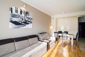 a living room with a couch and a table at Apartamenty Sun & Snow Tęczowe Wzgórze in Wisła