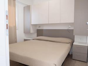 モノーポリにあるSanto Stefano Villageの小さなベッドルーム(ベッド1台、白いキャビネット付)