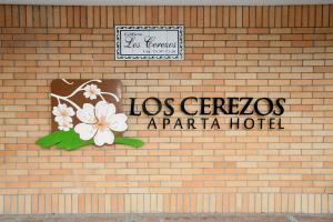 a sign on the side of a brick wall at Apartahotel Los Cerezos in Neiva