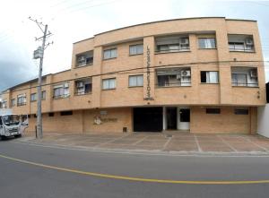 a brick building on the corner of a street at Apartahotel Los Cerezos in Neiva