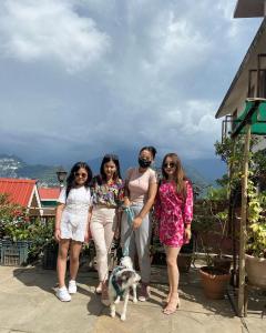 a group of women standing next to a dog at Backpackers Den (TRC) in Gangtok