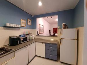 a kitchen with white cabinets and a white refrigerator at Gharoda PD Homestay CView in Kampong Baharu