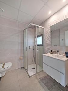 uma casa de banho com um chuveiro, um lavatório e um WC. em Sukha Apartments by NRAS em Gran Alacant