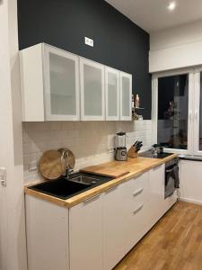 eine Küche mit weißen Schränken und einem Waschbecken in der Unterkunft Häuschen zentral gelegen in Detmold