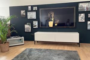 salon z telewizorem na niebieskiej ścianie w obiekcie Häuschen zentral gelegen w mieście Detmold