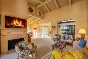 a living room with a fireplace and a tv at Palm Desert Charm Permit# STR2022-0119 in Palm Desert