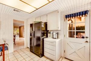 a kitchen with a refrigerator and a table and a door at Palm Desert Charm Permit in Palm Desert