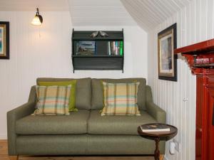 a living room with a green couch and a window at Beaton's Croft House - Uig Skye in Portree