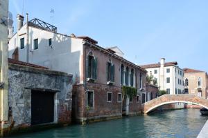 a canal in a city with a bridge and buildings at ARNOLDI-Rooftop in Venice