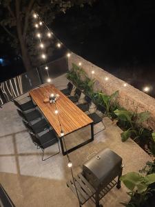 una mesa de madera y sillas con luces en el patio en Casa Blumenhaus - Casa de Campo con Jacuzzi en Zapopan, en Zapopan