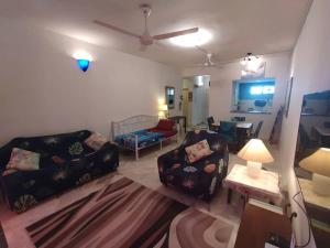 a living room with two couches and a ceiling fan at Gharoda PD Homestay CView in Kampong Baharu