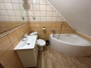 een badkamer met een wastafel, een bad en een toilet bij Apartament Nad Suwalskim Bulwarem in Suwałki