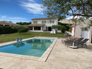 a swimming pool in front of a house at Maison Roquebeauresse in Pougnadoresse